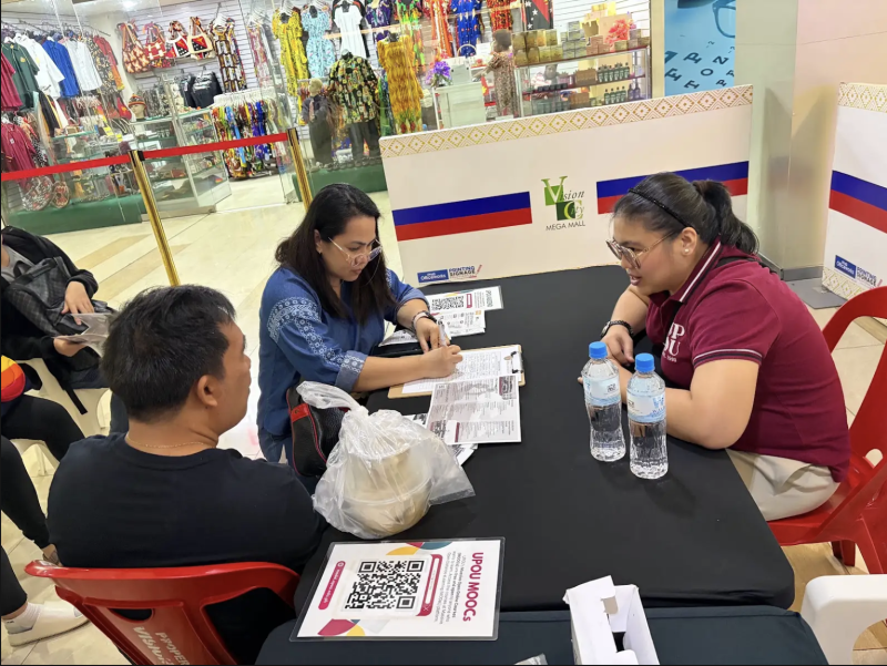 UPOU Master of Arts in Nursing Program Chair Asst. Prof. Ria Valerie Cabanes discusses the learning opportunities to participants visiting the UP VINTA booth.